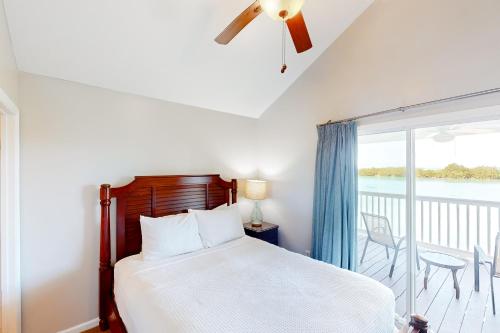 a bedroom with a bed and a balcony at Coconut House in Duck Key