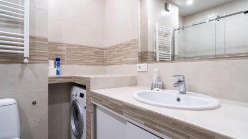 uma casa de banho com um lavatório e uma máquina de lavar roupa em Cozy apartment in the heart of Tbilisi em Tbilisi