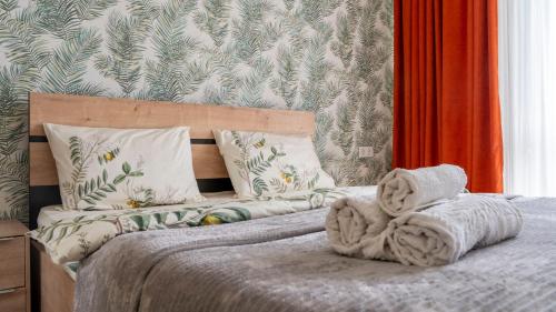 um quarto com uma cama com um cobertor e almofadas em Cozy apartment in the heart of Tbilisi em Tbilisi