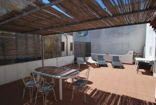 a patio with a table and chairs and a volley ball at Vulcanoconsult Appartamenti Spiaggia in Lipari