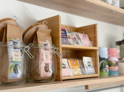 a shelf with jars of food and books on it at Ferienwohnung Hintermoos in Kißlegg