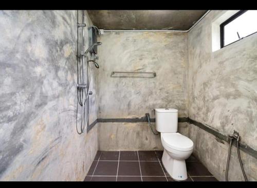 a bathroom with a toilet and a shower at Hillside cottage chalet studio in Tanah Rata