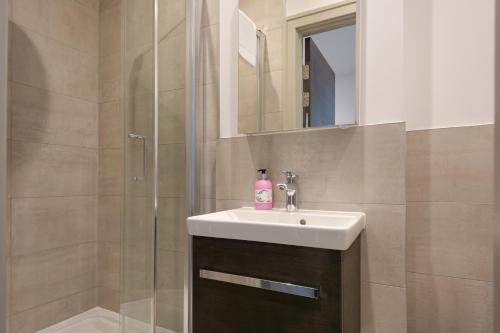 Pinner的住宿－One Bedroom Serviced Apartments in Harrow，一间带水槽和淋浴的浴室