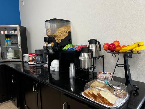 eine schwarze Arbeitsplatte mit einer Schüssel Brot und Obst in der Unterkunft Rodeway Inn in Dilley