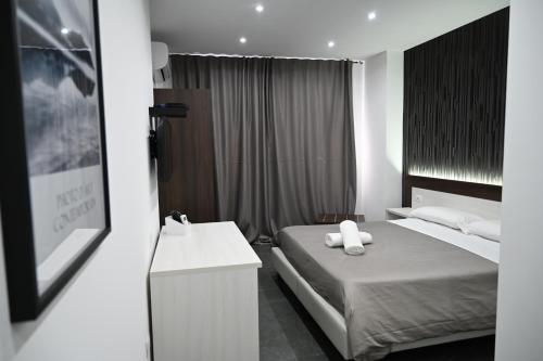 a hotel room with a bed and a sink at Hotel Blanc in Casoria