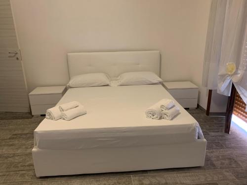 a bedroom with a white bed with towels on it at My Art home in Salerno