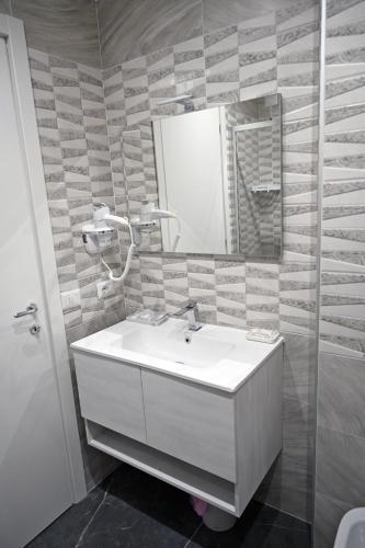 a bathroom with a white sink and a mirror at Hotel Blanc in Casoria