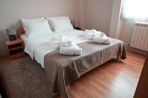 1 dormitorio con 1 cama grande y toallas. en Hotel Topcider, en Belgrado