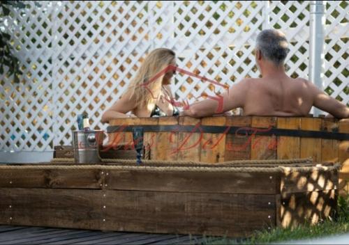 Ein Mann und eine Frau sitzen an einem Holztisch in der Unterkunft Cabañas Boutique Aires del Toro, Curacaví in Curacaví