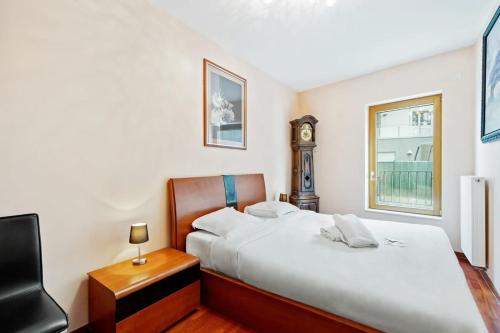 - une chambre avec un lit, une chaise et un réveil dans l'établissement Stylish 2-Bed Gem, Nature & Comfort, à Luxembourg