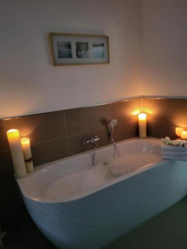 a bath tub with two candles and two lights at Aufatmen in Ahlbeck in Ahlbeck