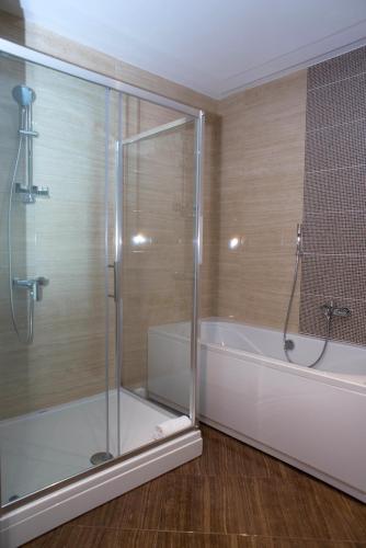 a bathroom with a shower and a bath tub at Hotel Royal Gold City - Hotel Ruža in Sarajevo