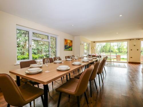 a large dining room with a long table and chairs at Coventina in Staines upon Thames