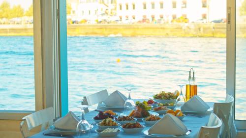 凱里尼亞的住宿－DOME Hotel & Casino at Central Kyrenia，一张桌子,上面有食物,享有水景
