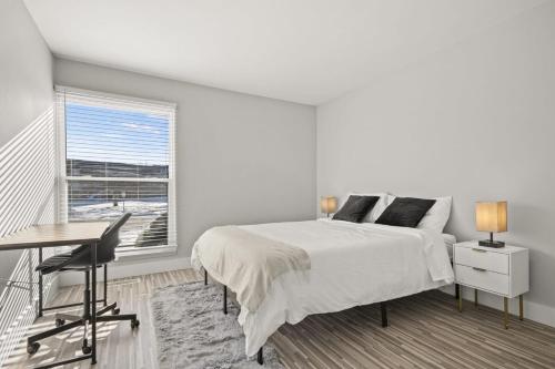 um quarto branco com uma cama, uma secretária e uma janela em Two-Bedroom Two-Bathroom Gem Near Downtown Rochester Hills em Rochester Hills