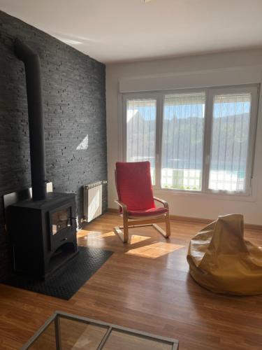 a living room with a red chair and a fireplace at Gorriones in Pelayos de la Presa