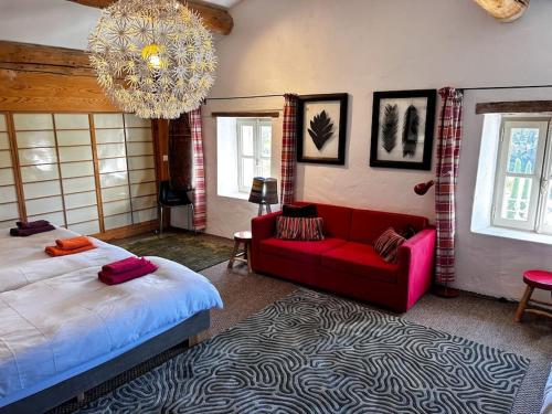 a bedroom with a bed and a red couch at La Magnanerie in Ménerbes