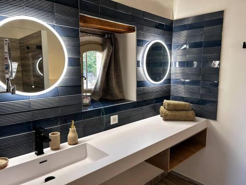 une salle de bain avec un lavabo et un miroir dans l'établissement La Magnanerie, à Ménerbes