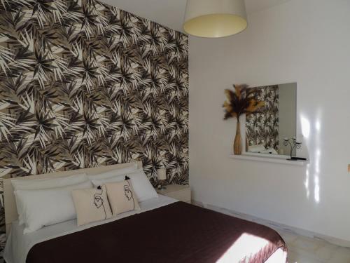 una camera da letto con un letto e carta da parati a palma di Dolphin House a Pompei