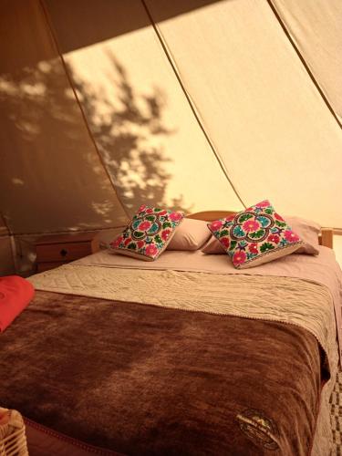 two pillows on a bed in a tent at Glamping, escapada en la naturaleza in San Clemente