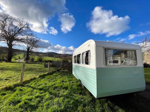 una furgoneta verde y blanca estacionada en un campo en Camping Les Ronds Duval face aux îles anglo-normandes, en Les Moitiers-dʼAllonne