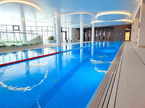 - une grande piscine d'eau bleue dans un bâtiment dans l'établissement Wunderbares Appartements mit Swimmingpoolbereich - Nemo Apartamenty Kolberg, à Kołobrzeg