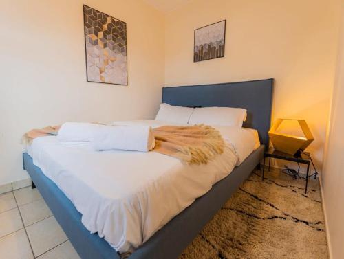 - une chambre avec un grand lit et des draps blancs dans l'établissement Cozy 1BR Apartment in Esch-sur-Alzette, à Esch-sur-Alzette
