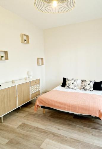 une chambre blanche avec un lit et une commode dans l'établissement Studio centre-ville au calme, à Espalion