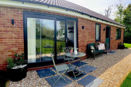 a screened in porch of a house with a table at Garden Room Dormston in Kington