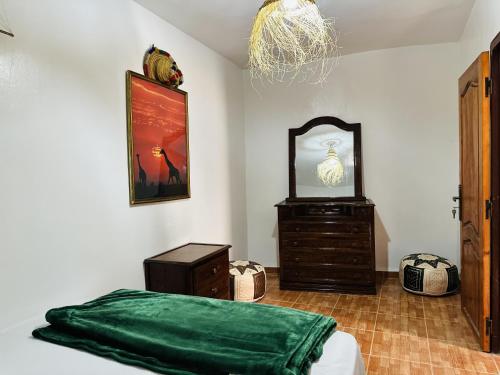 a bedroom with a bed and a dresser and a mirror at Azoul Surf Hostel Taghazout in Taghazout