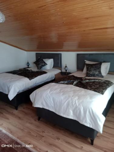 two beds in a room with wooden ceilings at Kapadokya'nın Büyüsüne Davet in Ürgüp