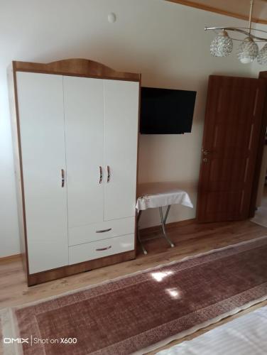 - une chambre avec une armoire blanche et une télévision dans l'établissement Kapadokya'nın Büyüsüne Davet, à Ürgüp
