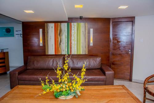 納塔爾的住宿－Garbos Soleil Hotel，客厅里一张棕色的皮沙发,配有桌子