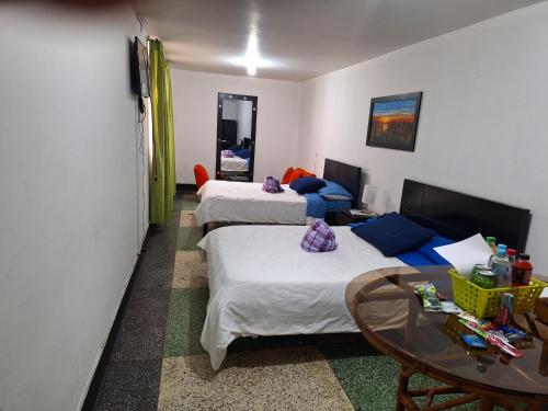 マニサレスにあるHOTEL GALICIA PLAZAのベッド2台とテーブルが備わるホテルルームです。
