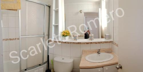 bagno con lavandino, servizi igienici e specchio di La serena Reinos de España a La Serena
