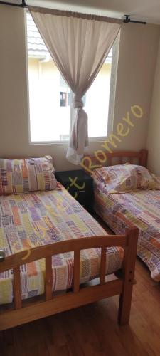 a bedroom with two beds and a window at La serena Reinos de España in La Serena