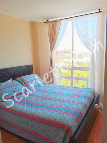 a bedroom with a bed and a large window at La serena Reinos de España in La Serena