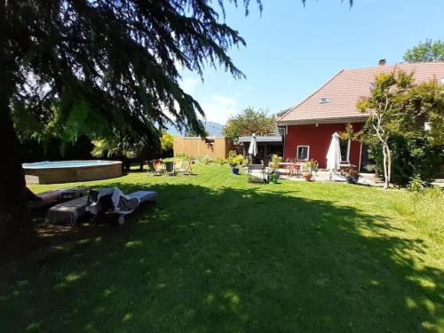 einen Hof mit einem Picknicktisch im Gras in der Unterkunft La cabane du bonheur in Aix-les-Bains