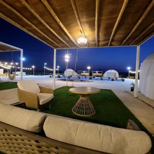 a living room with a couch and a table on a lawn at Desert Breeze in Al Ḩamrānīyah