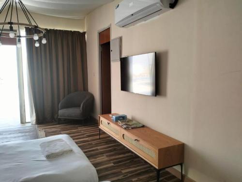 Desert Breeze في Al Ḩamrānīyah: غرفة في الفندق بها سرير ومكتب وتلفزيون