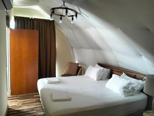 a bedroom with a large bed with white sheets and pillows at Desert Breeze in Al Ḩamrānīyah
