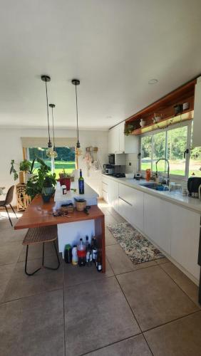 馬查利的住宿－Casa de Campo Coya Nativo，厨房配有白色橱柜和木桌