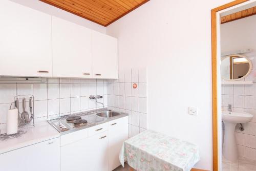 - une cuisine avec des placards blancs et un évier dans l'établissement Ferienwohnung für 2 Personen ca 30 qm in Viganj, Dalmatien Süddalmatien, à Viganj