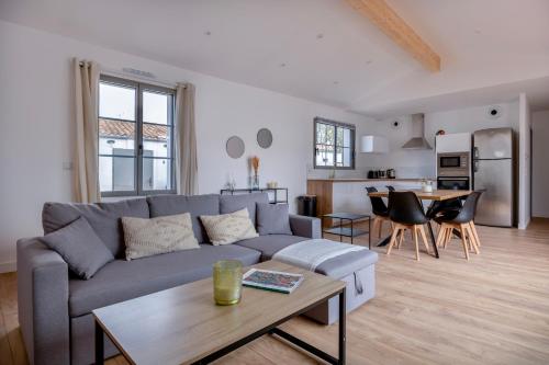 un salon avec un canapé et une table dans l'établissement Villa avec Jacuzzi et Clim à Marsilly, à Lagord