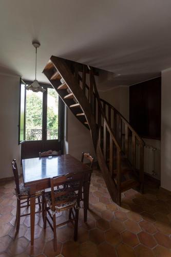 a dining room with a wooden table and a staircase at Pie' d'Ulivo in Bosco