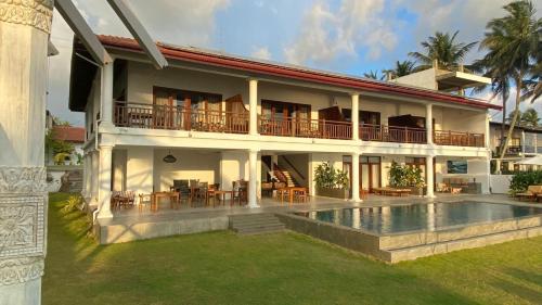 a house with a swimming pool in front of it at Sea Star Boutique Hotel in Hikkaduwa