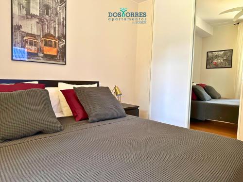 a bedroom with a bed with red pillows and a couch at Dos Torres Chill out in Zaragoza