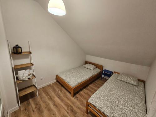 a small room with two beds and a shelf at Dom na Partykowie in Budzów