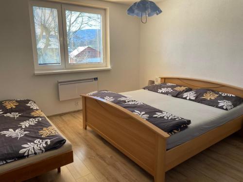 een slaapkamer met 2 bedden en een raam bij Ubytovanie u Aničky 