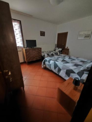 a bedroom with two beds and a television in it at B&B La Poiana in Urbino